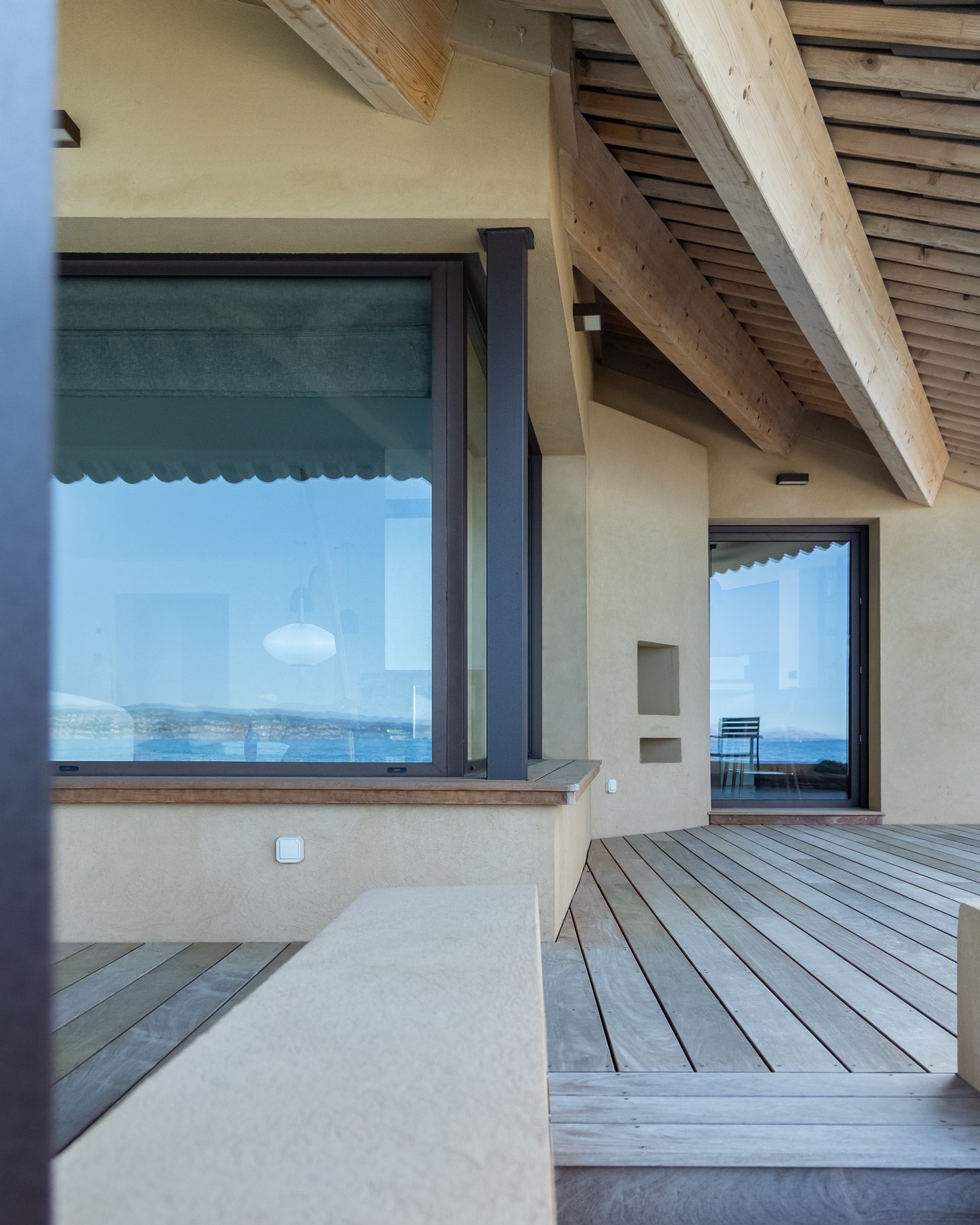 Châssis fixe en angle en aluminium coloris 8019 texturé sur une terrasse vue mer